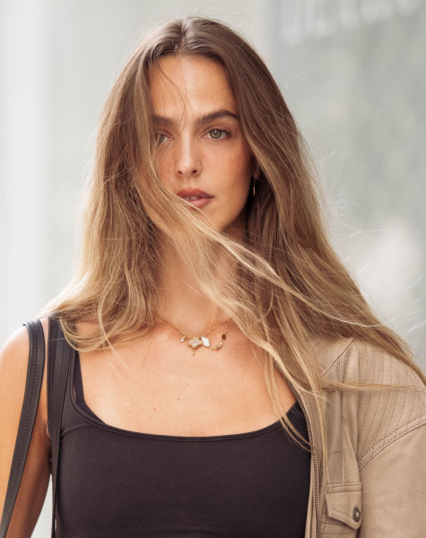 Woman wearing a black tank top and tan leather jacket